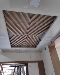 an unfinished ceiling with wooden beams in the middle and a window on the other side