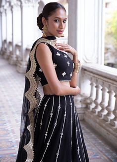 This look features a midnight black lehenga set. The lehenga has lines of gota and mirror work bootis descending into sequin & zari embroidered tiered borders. Teamed with a one shoulder blouse with pearl and mirror embellishments. A net dupatta with matching bootis and scallop border completes the look. Cancan & pockets are included. Composition: Blouse - Viscose georgette, lehenga -Viscose georgette ,Dupatta - Soft net Care: Dry Clean Only and Vacuum Storage This product can be customised for colour, sleeves, length of blouse and neck design Delivery : 2 weeks as the product is hand crafted. For more information and sizes please contact fabiliciousfashion@gmail.com or visit our Copenhagen studio.About the Designer : Renee Label was created in 2013,by the talented sister duo Pooja and Kar Black Lehenga, Georgette Lehenga, Scallop Border, Georgette Dupatta, Add Sleeves, Vacuum Storage, Georgette Blouse, Indian Couture, Net Dupatta