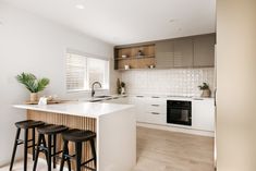 a kitchen with an island and three stools