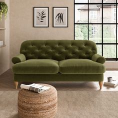 a green couch sitting on top of a rug next to a window