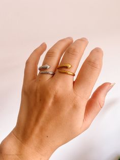 a woman's hand with two different rings on her fingers and one ring in the middle