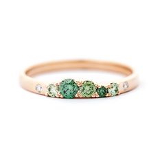 a gold ring with green stones on it