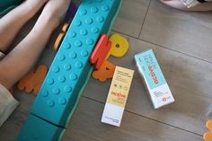 a person laying on the floor next to some legos and toothpaste tubes