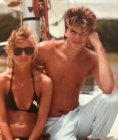 a man and woman sitting on the back of a boat