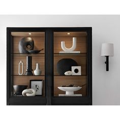 a black and white display case with vases on it's sides in a living room