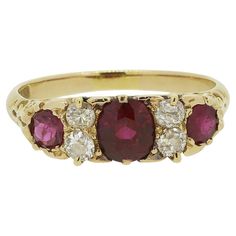 Here we have a classically styled three-stone ruby and diamond ring. This antique piece has been crafted from 18ct yellow gold and showcases a trio of rich red rubies; the largest of which sits at the centre. These focal stones are separated and accentuated by a duo of round faceted old mine cut diamonds atop of one another on either side. An ornate under-gallery design continues onto either shoulder before the piece is made complete by an otherwise plain shank. Condition: Used (Very Good) Weight: 3.8 grams Ring Size: N 1/2 (55) Band Width: 2mm Face Dimensions: 18mm x 6mm Ruby Weights: Approx. 1 (0.80ct), 2 (0.15ct) Total Diamond Weight: Approx. 0.28ct Marked: '18CT' Box: The Vintage Jeweller Ring Box Vintage Multi-stone Ruby Ring With Diamonds, Antique Ruby Ring With Multi-stone, Antique Multi-stone Ruby Ring In Yellow Gold, Vintage Multi-stone Ruby Ring In 14k Gold, Antique 14k Gold Ruby Ring With Multi-stone, Ruby And Diamond Ring, Ruby Diamond Rings, Gallery Design, La Face