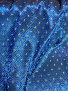 a blue and gold cloth with small flowers on it