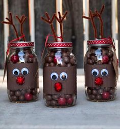 three mason jars filled with chocolate covered candies and reindeer noses