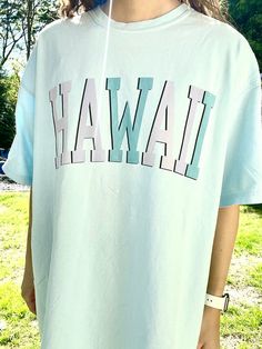 "Such a cute tee for summer! Comfort Colors chambray (light blue) t-shirt with \"HAWAII\" in blue and purple, with a black outline. Model is 5'4\" and wearing a size XL for an oversized look. 100% cotton." Light Blue T-shirt With Letter Print For Spring, Blue Slogan T-shirt For Summer, Casual Light Blue T-shirt For Summer, Light Blue Crew Neck T-shirt With Text Print, Light Blue Short Sleeve T-shirt For Summer, Light Wash Crew Neck T-shirt With Letter Print, Trendy Blue Pre-shrunk T-shirt, Light Blue Short Sleeve T-shirt With Text Print, Relaxed Fit Light Blue T-shirt With Text Print