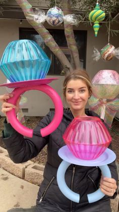 a woman is holding up some colorful objects