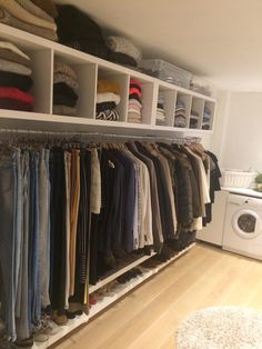 a closet filled with lots of clothes next to a dryer