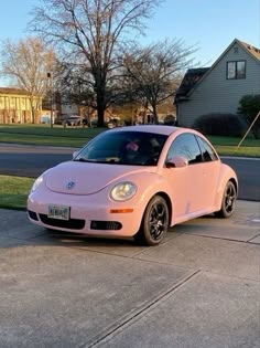 a pink car parked in front of a house