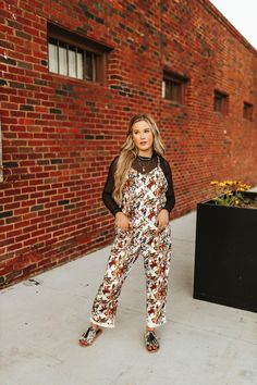 Hit the trail in style with our Buckaroo Jumpsuit! This comfy one-piece features a playful horses and cowboys graphic, perfect for adding a touch of Western charm to your wardrobe. Whether you're exploring the great outdoors or just lounging around, this jumpsuit is ready for adventure. Casual Fall Overalls For Outdoor, Casual Fall Outdoor Overalls, Printed Jumpsuits And Rompers For Fall, Casual Outdoor Overalls And Rompers, Casual Outdoor Overall Jumpsuits And Rompers, Casual Printed Jumpsuits And Rompers For Fall, Trendy Brown Jumpsuits And Rompers For Spring, Trendy Brown Jumpsuits For Spring, Trendy Jumpsuits And Rompers For Fall Day Out