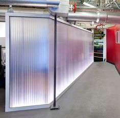 an empty room with metal partitions and red walls