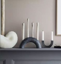 candles are sitting on top of a mantle with an iron ring and other decorative items