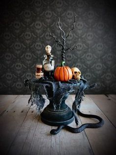 a table topped with halloween decorations on top of a wooden floor next to a wall