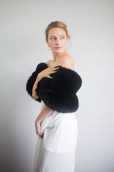 a woman in a white dress and black fur stole