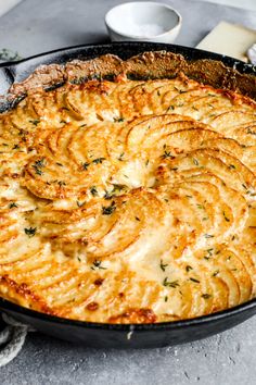 a pan filled with food sitting on top of a table next to utensils