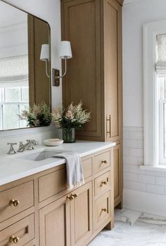 a bathroom with wooden cabinets and marble counter tops