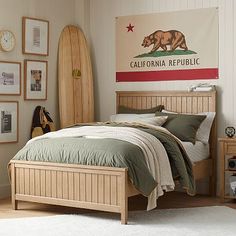 a bed room with a neatly made bed and a surfboard hanging on the wall