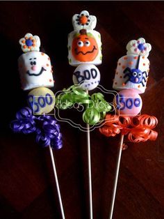 four colorful lollipops with faces on them sitting on top of a table