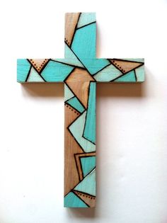 a wooden cross that has been painted with blue and brown designs on it's sides