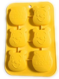 four bear shaped ice trays with faces drawn on the top one is yellow and the other has bears'heads