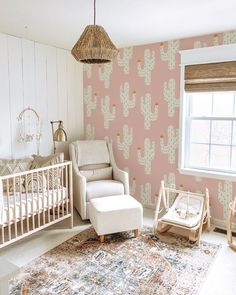 a baby's room decorated in pink and white with cactus wallpaper on the walls