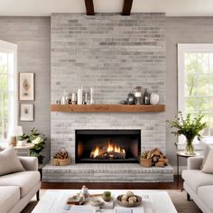 a living room filled with furniture and a fire place in front of a brick wall