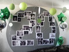 a wall with pictures and balloons hanging from it