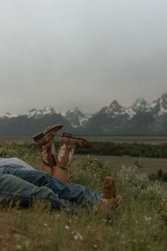 a person laying on the ground with their feet up in the air while wearing boots