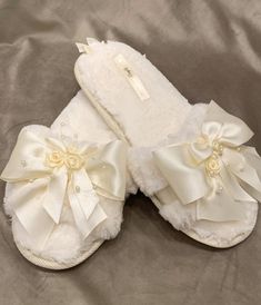 a pair of white slippers with bows on them