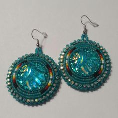 Hand-made beaded earrings: Colors: Teal w/fire colors  Closure: Hook size: 2 inches Turquoise Beaded Round Earrings, Beaded Round Earrings For Festival, Multicolor Beaded Crystal Earrings, Handmade Turquoise Beaded Earrings With Czech Glass, Unique Beaded Earrings With Bead Caps For Gift, Unique Turquoise Beaded Earrings, Multicolor Czech Glass Beaded Earrings For Party, Festive Beaded Round Earrings, Festive Turquoise Beaded Earrings