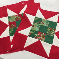 three red and white quilts are laying on top of each other, one is green