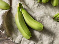 some green bananas are laying on a cloth