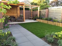 a small backyard garden with grass and flowers