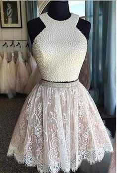 a white dress with pearls on the neck and skirt is sitting on a mannequin