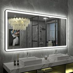 a bathroom with two sinks and a large mirror above the sink is illuminated by lights