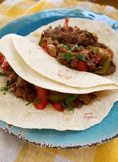 two shredded beef tacos on a plate with the title slow cooker shredded beef fajitas