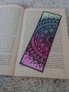 an open book with a design on the cover and some writing in front of it