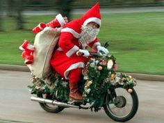 a man dressed as santa claus riding on a motorcycle