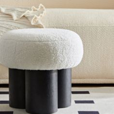 a black and white ottoman sitting on top of a rug