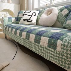 a green and white couch with pillows on it