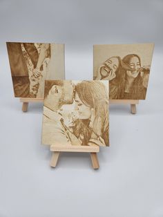 three wooden eases with pictures of people on them and one is holding a woman's head