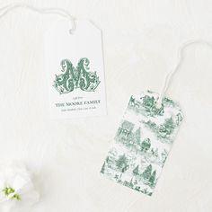 the monogrammed luggage tag is next to a flower on a white background with green lettering