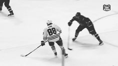 two hockey players in black and white playing on an ice rink with the puckers behind them