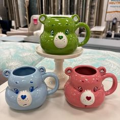 three ceramic mugs are sitting on a table