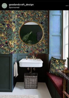 a bathroom with green walls and floral wallpaper in the corner, along with a white sink