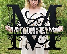 a woman holding up a metal letter that says m and w