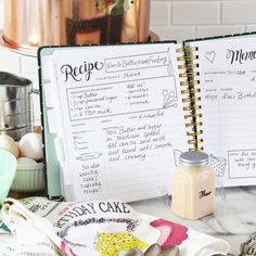 an open recipe book sitting on top of a counter next to other kitchen utensils